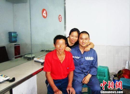 狱警为不识字的李明华化名的母亲细读家书。卢洋摄