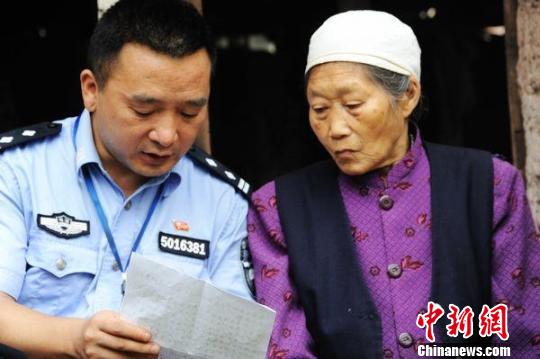 狱警为不识字的李明华化名的母亲细读家书。卢洋摄