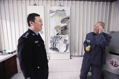 4月20日，天津清河农场金钟监狱，狱警沈欢看着犯人祝子的书画作品，笑了，祝子也笑了。